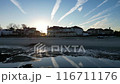 A beach with a sunset in the background 116711176