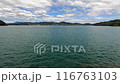 青空と白い雲と穏やかな海を望む車窓 116763103
