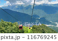 Modern rope way cabins against blue sky and mountain tops. Krasnaya Polyana resort, Soschi, Russia 116769245