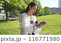 年輕女子在公園長椅上的筆記本上記下筆記 116771980