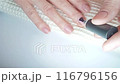 Gel polish manicure step-by-step video tutorial. Step 7 Nails base coat. Applying a base coat rubbing into the surface of the nail for better adhesion 116796156