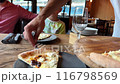 waiter serving cheese pizza for family in restaurant putting slices on tables 116798569