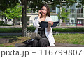 年輕女子打電話時在筆記本上做筆記 116799807