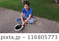 A beggar boy asks for alms on the street and rejoices at the thrown money. 116805773