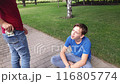 A beggar boy asks for alms on the street and rejoices at the thrown money. 116805774