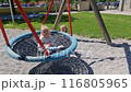 Little children ride on a swing. Two girls ride each other and play on the playground. 116805965