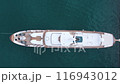 Aerial view of a beautiful luxury snow-white yacht moored in a blue bay. Private boat swaying on the waves. Summer vacation, rest by the sea.  116943012