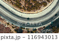 Aerial view of a mountain highway. Cars driving along a winding rocky road. 116943013