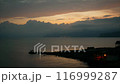 Timelapse. Sunset over the sea. Small silhouettes of fishermen on the sea breakwater. 116999287