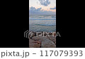 Evening at the sea, the waves roll on the rocky shore 117079393