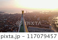 Enjoy a Stunning Aerial View of Venice at Sunrise, Featuring a Statue Placed on a Rooftop 117079457
