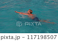 Teenage Boy Swimming in Pool on a Sunny Day 117198507