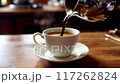 pour the coffee into the cup on the table 117262824