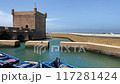 Fortress, bridge and typical blue boat in little harbor of Essaouira 117281424