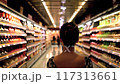 Back view of woman walking in an aisle of among shelves in supermarket 117313661