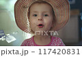 Funny little charming girl looks at the camera and talks. Close-up shot. A smiling child speaks and gives a high five. 117420831