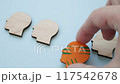 A hand replaces identical heads with a unique colorful one. Individuality and creativity. 117542678