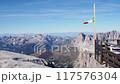 A lookout point with an Italian flag and a high mountain in the Dolomites in the background 117576304