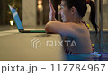 Woman Typing on Laptop from Poolside 117784967
