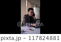 Attentive Asian interior designer having a focused conversation on the phone  117824881