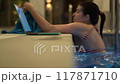 Woman Typing on Laptop from Poolside 117871710