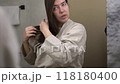 Woman combing her hair in front of mirror. Concept of health care and morning routine 118180400