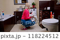 Woman Enjoying the Heavenly Scent of Fresh Laundry in a Cozy European Bathroom, Relishing Spotless and Soft Towels 118224512