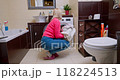 Woman with a slender figure checks a freshly washed blouse in a cozy European bathroom after finishing laundry 118224513