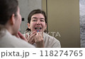 Woman brushing braces teeth by orthodontic brush. Female cleaning oral brackets. 118274765
