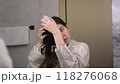 Woman combing her hair in front of mirror. Concept of health care and morning routine 118276068