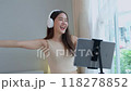Asian women and beautiful bloggers wear headphones dancing videos by smartphone cameras. Creator vlogger talent dancing enjoys hobby content recording show video sharing on social media. 118278852