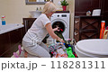 Woman Sorting Laundry on the Bathroom Floor in a Bright, Cozy Space 118281311