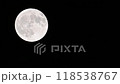 The white full moon of the harvest moon shines against the black night sky. 118538767