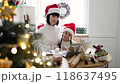 Mother and daughter celebrating Christmas at home with laptop 118637495