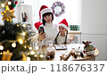 Mother and daughter taking Christmas selfie in kitchen with decorations 118676337