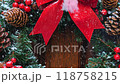 Christmas wreath with a red bow, pine cones, and festive decorations on a wooden door 118758215