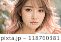 A young woman with flowing hair and floral accents poses in a serene setting during golden hour 118760381