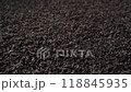 Background of black fanning or broken loose leaf tea slowly rotating. Close-up, angled view 118845935