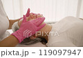 Beautician preparing cosmetic product for facial treatment 119097947