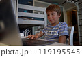 caucasian little boy studying online at home using laptop 119195545