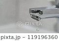 Drop of water drips from the tap. Beautiful fresh and clean water flowing from a tap. Close-up front view slow motion broken chrome faucet in the bathroom. Everyday problems, wasting water and energy 119196360
