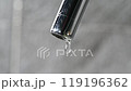 Drop of water drips from the tap. Beautiful fresh and clean water flowing from a tap. Close-up front view broken chrome faucet in kitchen. Everyday problems, wasting water and energy 119196362