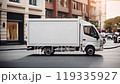 White Delivery Truck Driving Through a Busy City Street at Sunset 119335927