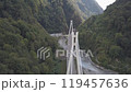 Aerial around epic modern cable-stayed bridge Adler road Krasnaya polyana Sochi Russia suburban freeway cars traffic among high mountains. Natural landscape green slopes. Travel landmark. High quality 119457636