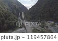 Aerial around epic modern cable-stayed bridge Adler road Krasnaya polyana Sochi Russia suburban freeway cars traffic among high mountains. Natural landscape green slopes. Travel landmark. High quality 119457864