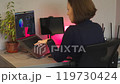 Young woman using a laptop and graphic tablet at home in the evening 119730424