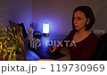 Young woman using a laptop and graphic tablet at home in the evening 119730969
