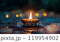 A single burning diyas. Diwali, the Hindu festival of lights. Moving flame and lights in the background 119954902
