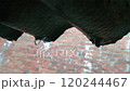 Heavy Rain Pouring Over a Corrugated Roof with Brick Wall Background 120244467
