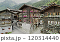 Scenic Drone View of a Swiss Alpine Village with Traditional Wooden Chalets and Blooming Geraniums 120314440